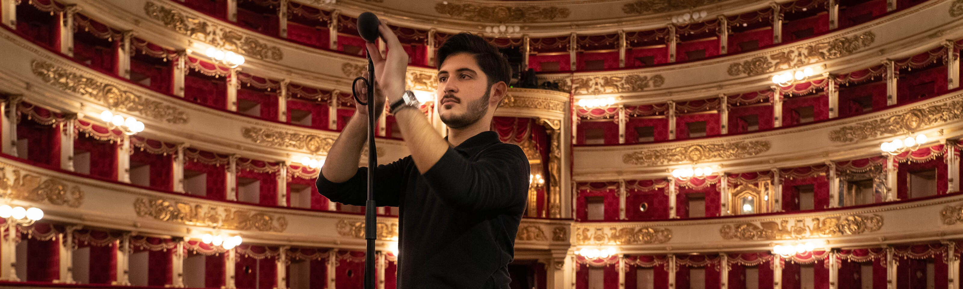 Un tecnico del suono sistema un microfono in teatro